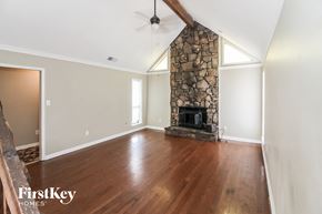 Memphis house for rent - a living room with a stone fireplace and wooden floors