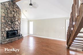 Memphis house for rent - a renovated living room with a stone fireplace and wooden floors