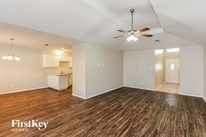 Arlington house for rent - an empty living room with a ceiling fan and a kitchen