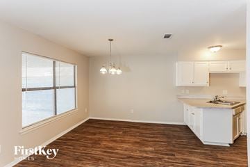 Arlington house for rent - a kitchen with white cabinets and a large window and a counter top
