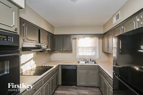Memphis house for rent - a kitchen with gray cabinets and black appliances