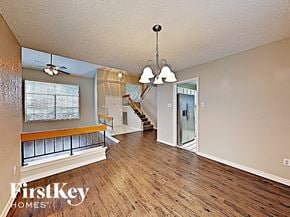 Garland house for rent - A spacious living room with wood flooring and a staircase in the background.