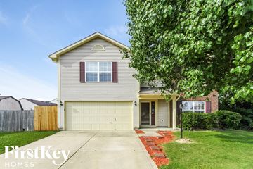 Indianapolis house for rent - a white house with a white garage door and a lawn