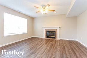 Indianapolis house for rent - a living room with a fireplace and a ceiling fan