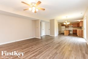 Indianapolis house for rent - an empty living room with a ceiling fan and a kitchen
