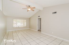 Bradenton house for rent - A spacious room with a ceiling fan and tiled floor.