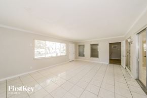 Bradenton house for rent - A spacious empty room with tiled flooring and white walls.