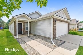 Indianapolis house for rent - a white house with a driveway and a garage door