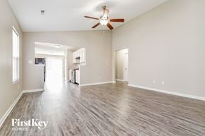 Indianapolis house for rent - the living room and kitchen of an empty house with a ceiling fan
