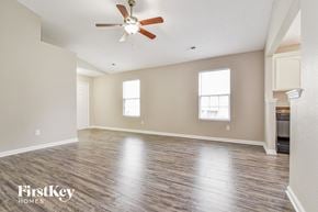 Indianapolis house for rent - the spacious living room with hardwood floors and a ceiling fan