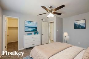 Phoenix house for rent - A bedroom with a bed, dresser, and ceiling fan.