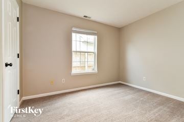 Indianapolis house for rent - a spacious living room with carpet and a window