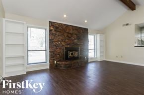 Memphis house for rent - a living room with a stone fireplace and wooden floors