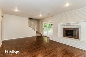 Fort Worth house for rent - a living room with a fireplace and wooden floors and a staircase