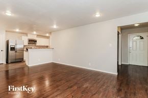 Fort Worth house for rent - an empty living room and kitchen with wood flooring and white walls