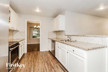 Fort Worth house for rent - a kitchen with white cabinets and marble counter tops