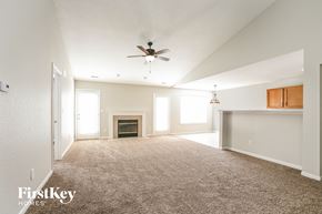 Indianapolis house for rent - A spacious living room with a fireplace and a ceiling fan.