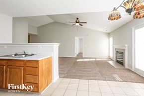 Indianapolis house for rent - A spacious living room with a kitchen area and a fireplace.