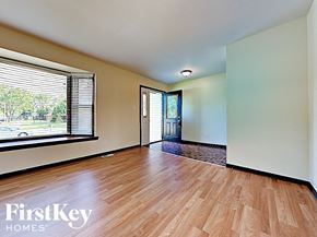 Matteson house for rent - an empty living room with wood floors and a large window
