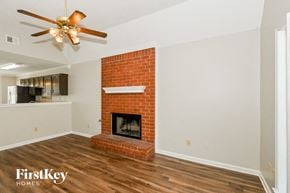 Olive Branch house for rent - A room with a fireplace and a ceiling fan.