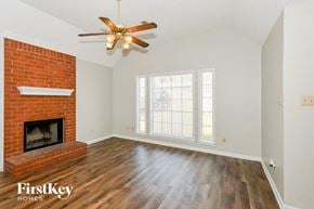 Olive Branch house for rent - A room with a fireplace and a ceiling fan.