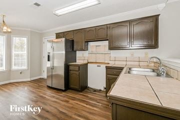 Olive Branch house for rent - A kitchen with wooden cabinets and a stainless steel refrigerator.