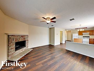 Fort Worth house for rent - a living room with a fireplace and a ceiling fan
