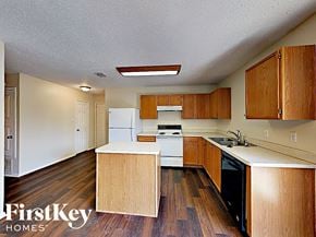 Fort Worth house for rent - an empty kitchen with wood floors and white appliances