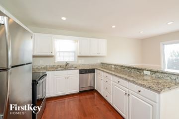 High Point house for rent - A kitchen with white cabinets and a granite countertop.