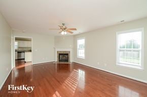 High Point house for rent - A spacious room with a fireplace and a ceiling fan.
