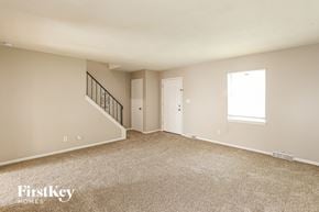 Grandview house for rent - A spacious empty room with a staircase and two doors.