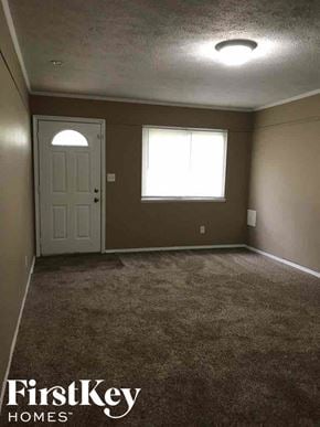 Indianapolis house for rent - A room with a carpeted floor, a door, and a window.