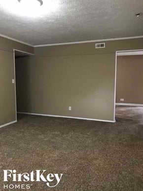 Indianapolis house for rent - A room with a carpeted floor and a doorway leading to another room.