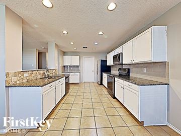 Denton house for rent - a large kitchen with white cabinets and counter tops