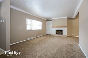Hazelwood house for rent - A spacious room with a fireplace and a window.