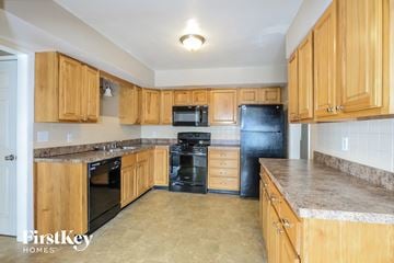 Hazelwood house for rent - A kitchen with wooden cabinets and black appliances.