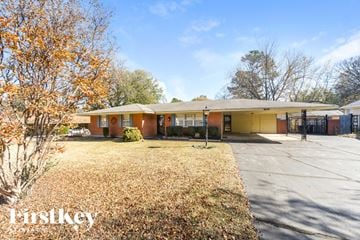 Bartlett house for rent - a small yellow house with a driveway and a covered porch