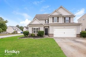 Rex house for rent - a house with a white garage door and a lawn