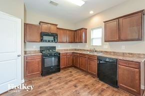 Rex house for rent - a kitchen with wood flooring and wooden cabinets