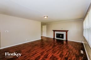 Indianapolis house for rent - A room with a fireplace and wooden floors.