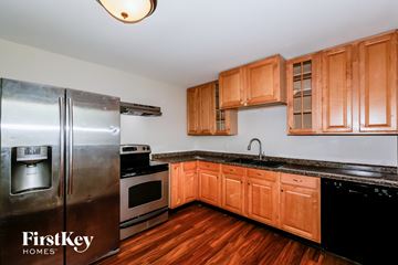 Indianapolis house for rent - A kitchen with wooden cabinets and a stainless steel refrigerator.