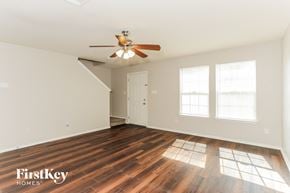 Dallas house for rent - A room with a wooden floor and a ceiling fan.
