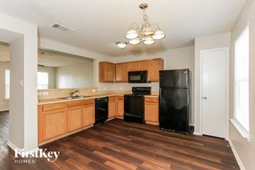 Dallas house for rent - A kitchen with wooden cabinets and black appliances.