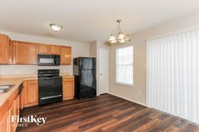 Dallas house for rent - A kitchen with wooden cabinets and black appliances.