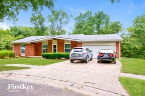 Florissant house for rent - a small brick house with two cars parked in the driveway