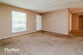 Florissant house for rent - an empty living room with carpet and a window