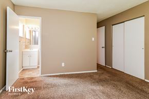 Florissant house for rent - a bedroom with a carpeted floor and doors to a bathroom