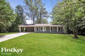 Douglasville house for rent - a small house with a lawn and trees