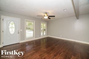 Douglasville house for rent - the living room of a house with wood floors and a ceiling fan