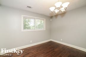 Douglasville house for rent - a bedroom with hardwood flooring and a window and a chandelier